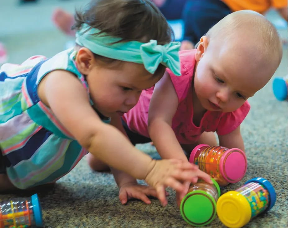 a baby and a person playing with toys