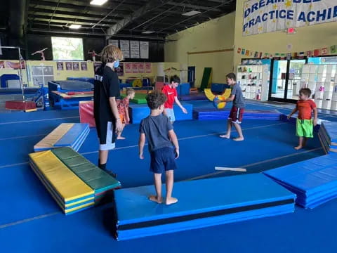 a group of children playing on a mat in a classroom