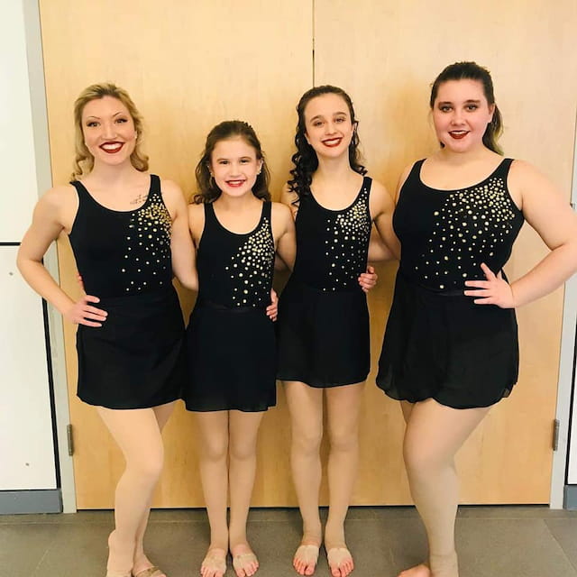 a group of women in black dresses