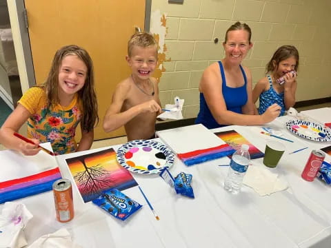 a group of children sitting at a table with a white tablecloth