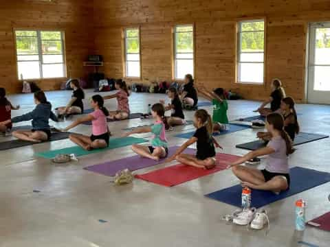 a group of people sitting on mats in a room