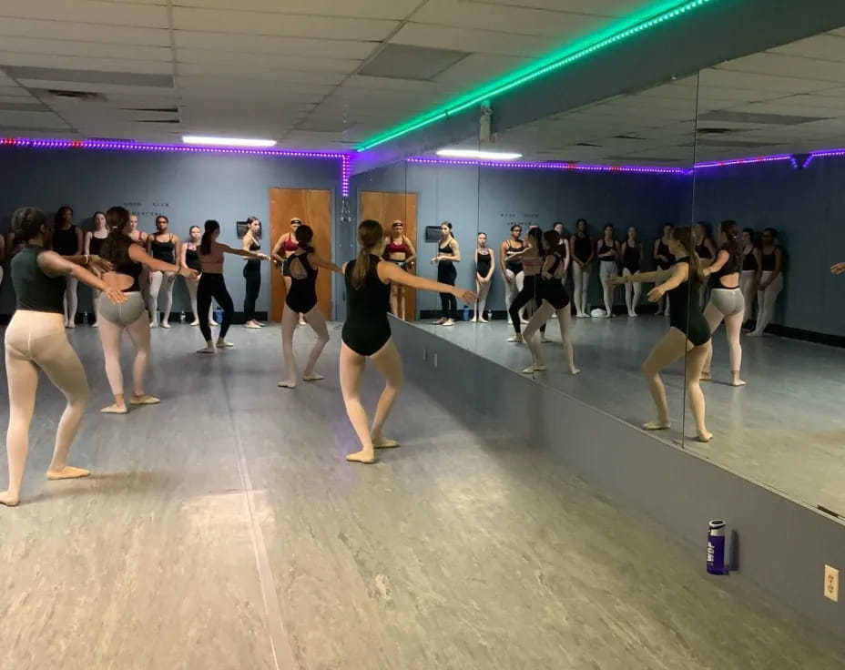 a group of people dancing in a room with purple walls
