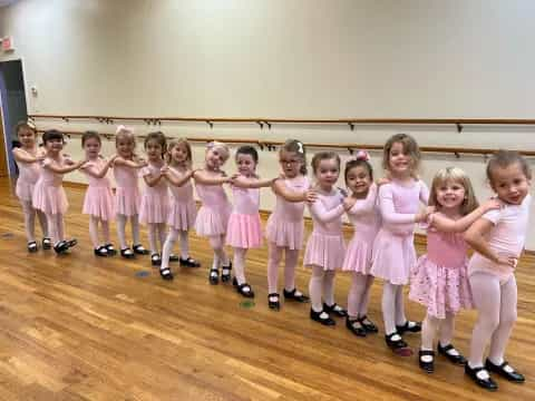 a group of girls in pink dresses