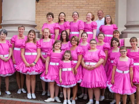 a group of people wearing pink dresses