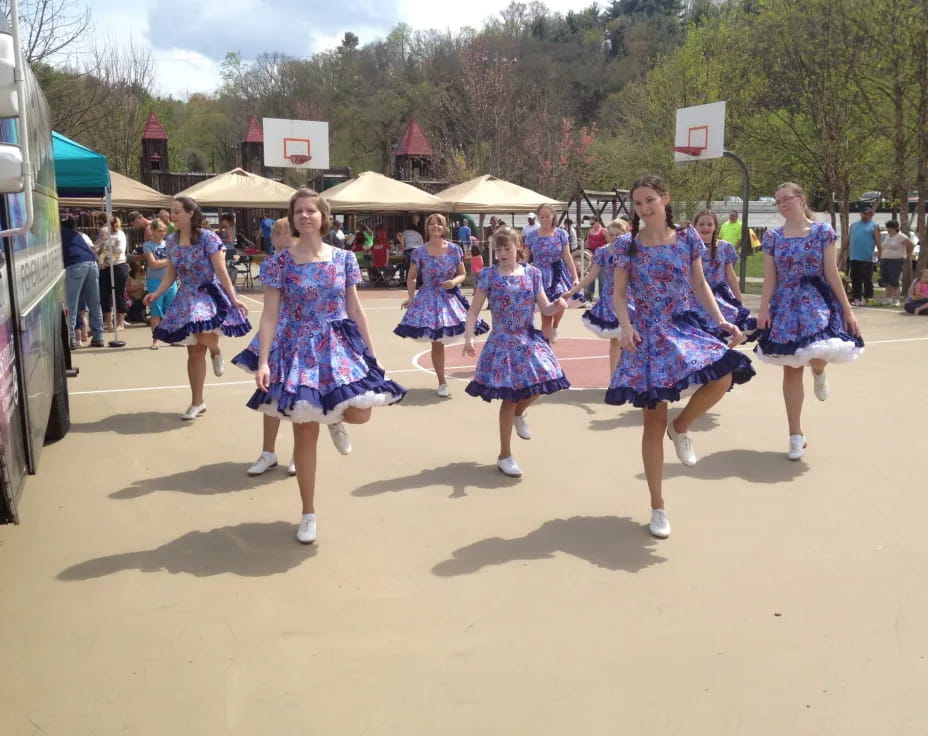 a group of women in dresses dancing