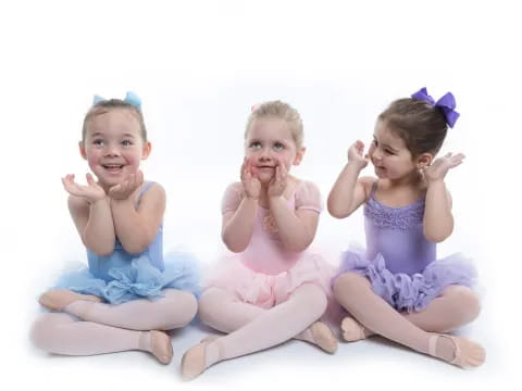 a group of children sitting on the ground posing for the camera