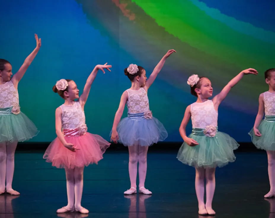 a group of girls in dresses dancing