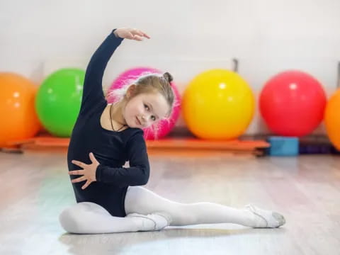 a girl with her arms up and a bunch of balloons