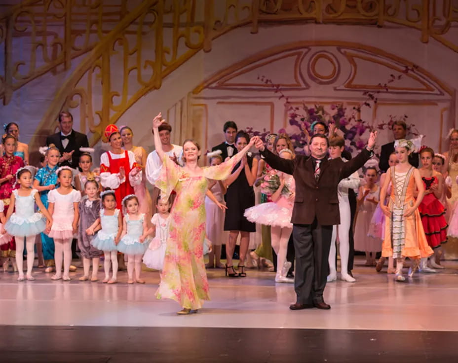 a man and woman dancing on a stage with a group of people