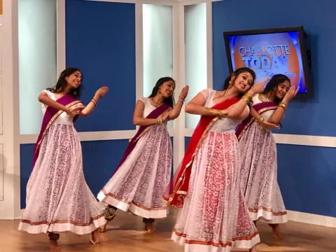 a group of women in dresses dancing
