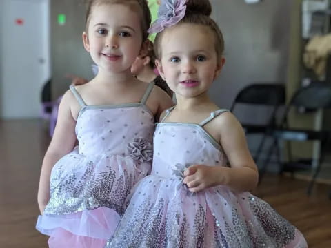 two girls wearing dresses and posing for a picture