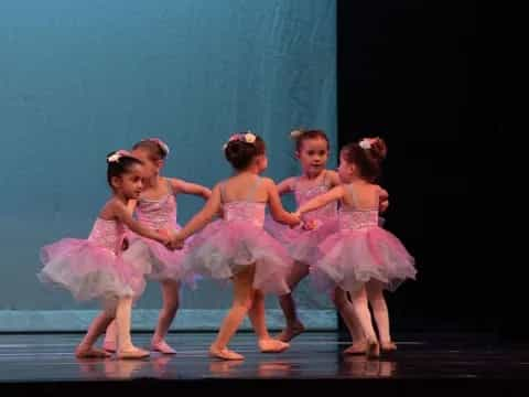 a group of girls in dresses dancing