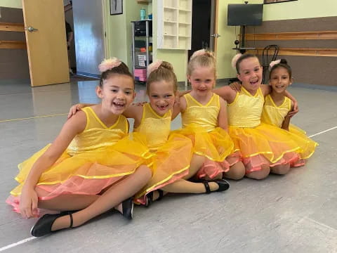 a group of children in yellow dresses