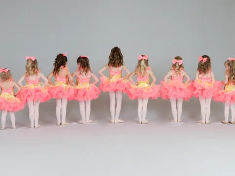 a group of girls in pink dresses