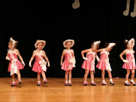 a group of girls in dresses on a stage