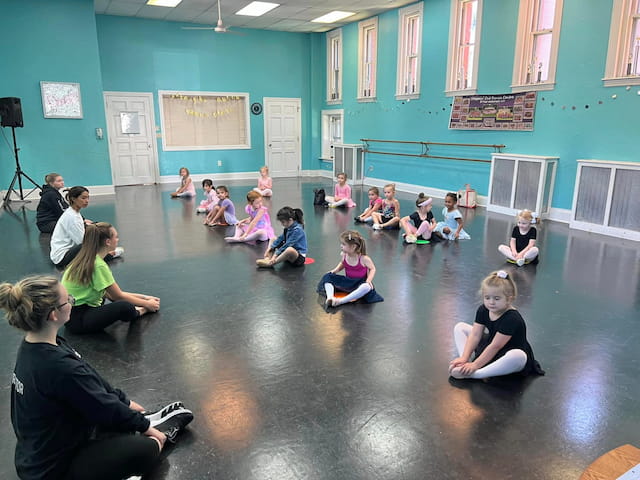 a group of children sitting in a circle in a room