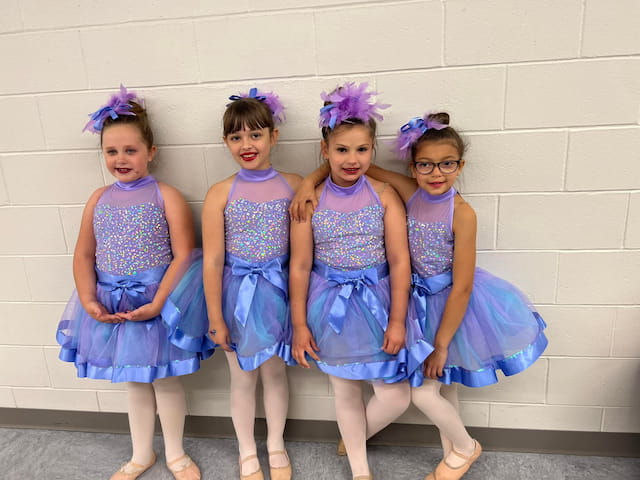 a group of girls in blue dresses