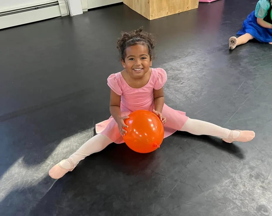 a girl sitting on a ball