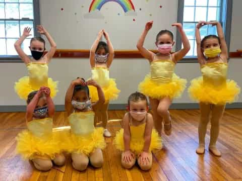 a group of children wearing yellow dresses