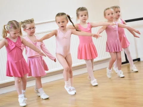 a group of girls in pink dresses