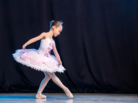 a girl in a dress dancing on a stage