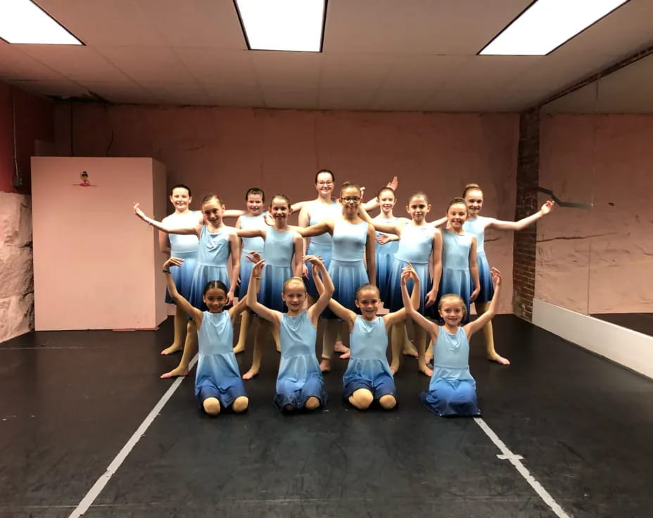 a group of girls in blue dresses posing for a photo