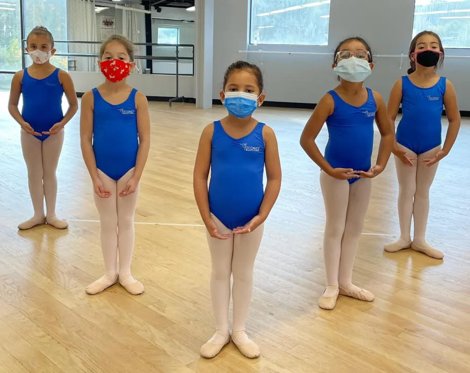 a group of women wearing blue scrubs and masks