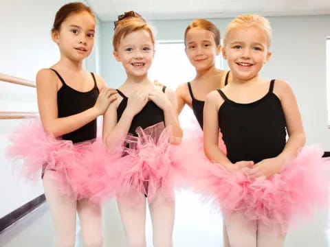 a group of girls in pink and black dresses