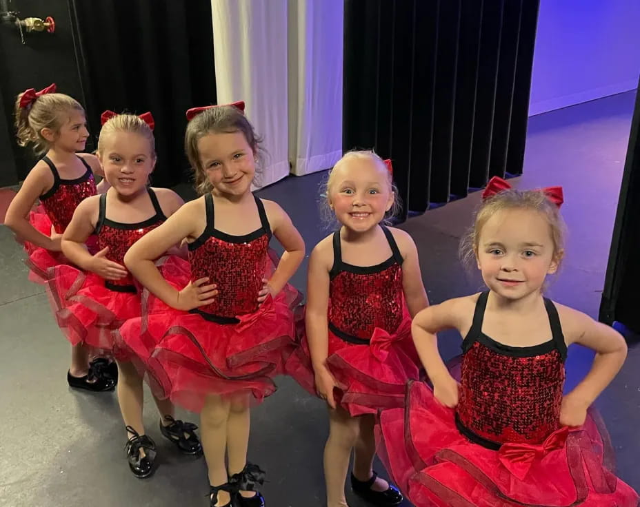 a group of girls in red dresses