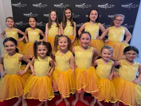 a group of girls in yellow dresses