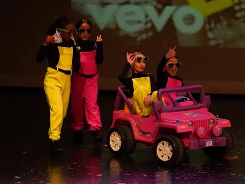 a group of people in clothing standing next to a toy car