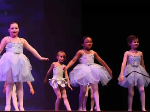 a group of girls in dresses dancing