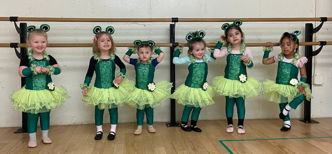 a group of children in green dresses