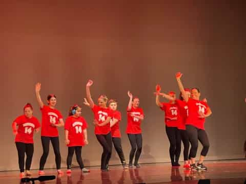 a group of women in red shirts