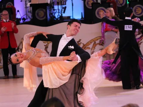 a man dancing with a woman in a dress and a man in a suit