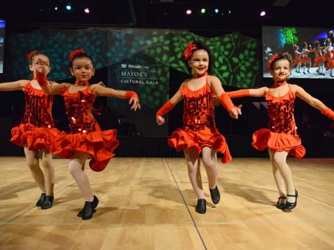 a group of girls dancing on a stage