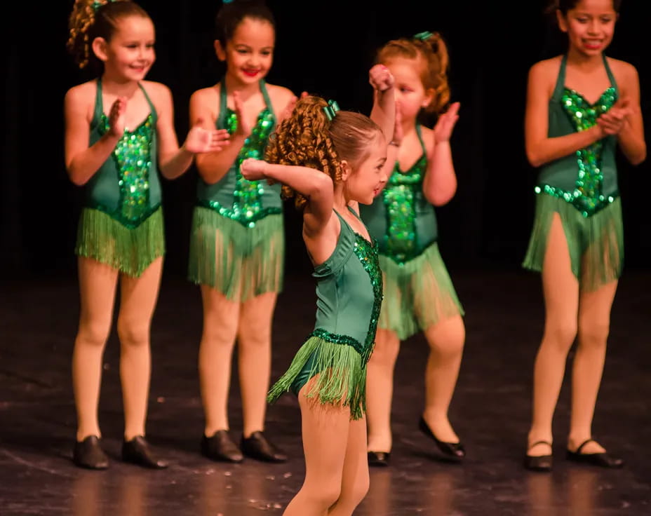 a group of girls in green dresses