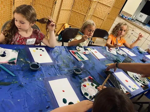 a group of children sitting around a table with paper on it