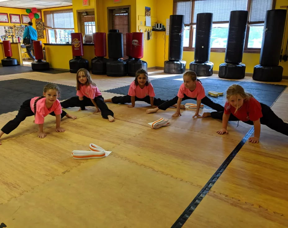 a group of children sitting on the floor playing a game