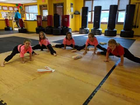 a group of children sitting on the floor playing a game