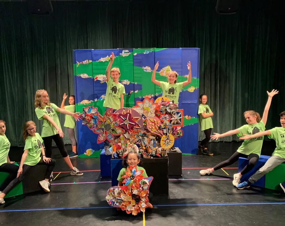 a group of people in green shirts dancing on a stage