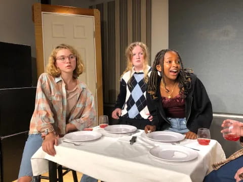 a group of women sitting at a table with plates and glasses