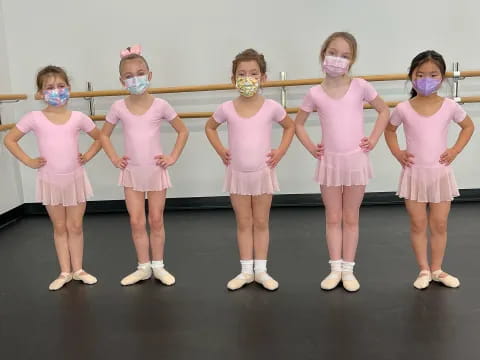 a group of girls wearing pink dresses