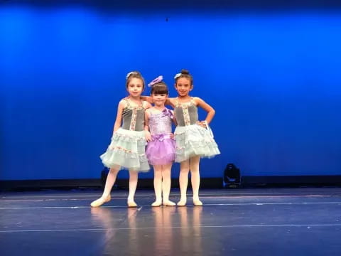 a group of girls in dresses on a stage