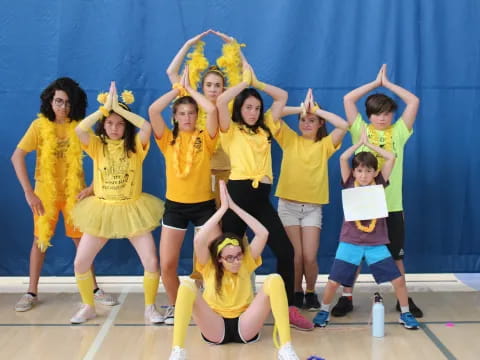 a group of girls wearing yellow shirts and posing for a photo