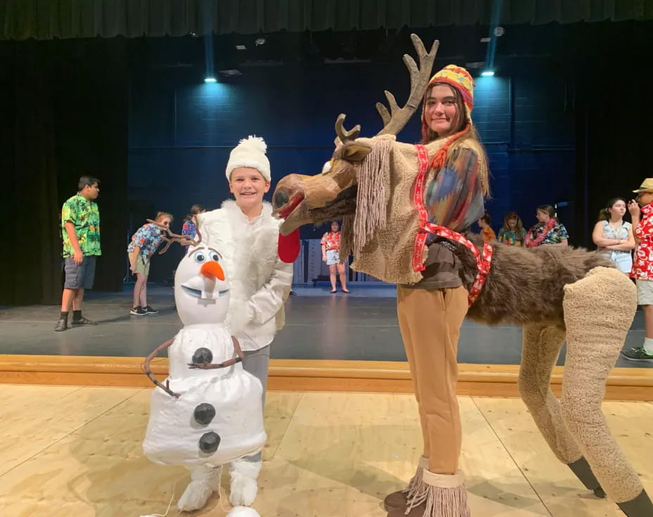 a person and a couple of stuffed animals on a stage