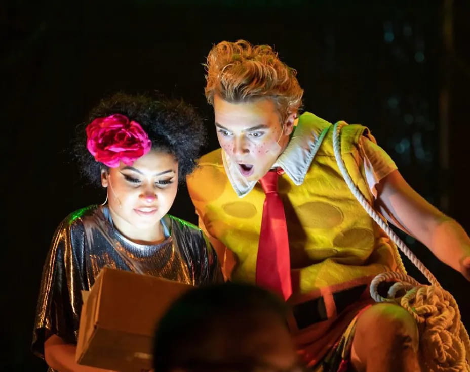 a man and woman sitting on a stage