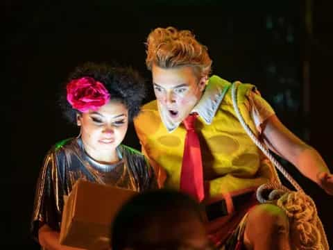 a man and woman sitting on a stage