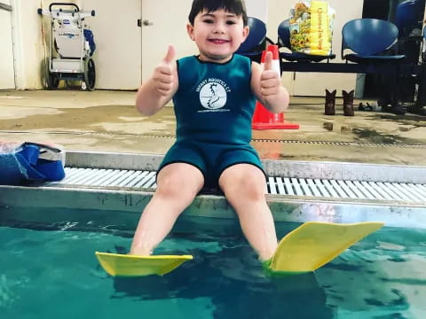 a boy sitting in a pool