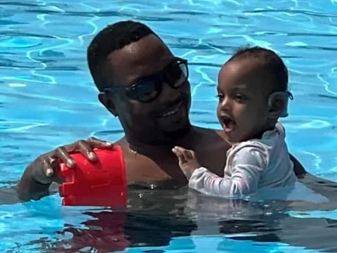 a person and a baby in a pool